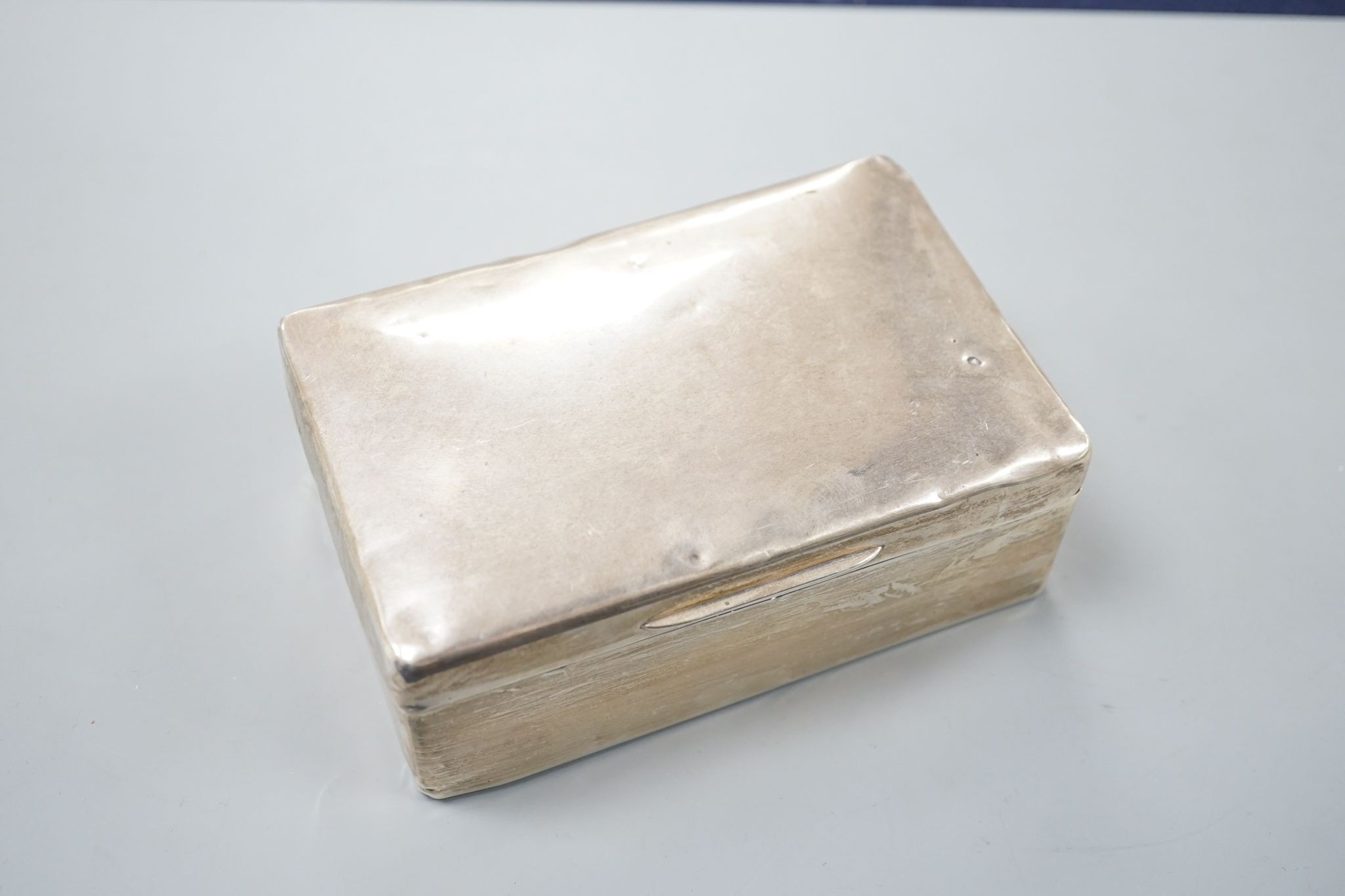 A silver mounted cigarette box, two silver vestas and a silver matchbox sleeve.